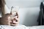 teenager sidder med mobiltelefon