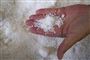En håndfuld salt taget op fra et stort kar med salt