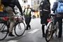 En politibetjent imellem en stor flok cyklister han vifter med armen