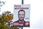 En valgplakat i en lygtepæl med en mand på