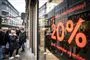 folk står udenfor butik under black friday 
