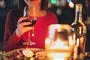 en dame med et glas vin ved et bord