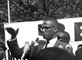Malcolm X på en talerstol. Billedet er gammelt og i sort/hvid.