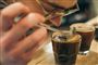 En mand dufter til en kop kaffe