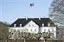Et hvidt slot med sort tag og flag på toppen