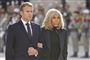 Emmanuel og Brigitte Macron arm i arm udenfor klædt i sort.