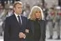 Emmanuel og Brigitte Macron arm i arm udenfor klædt i sort.