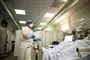 læge står ved patient i seng