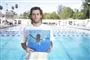 mand står med pladecover ved swimmingpool