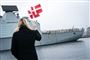 kvinde med flag med fregat i baggrunden 