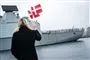 kvinde med flag med fregat i baggrunden 