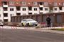 En politibil ved et garageanlæg. Der er afspærringstape i forgrunden. 