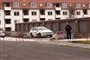 En politibil ved et garageanlæg. Der er afspærringstape i forgrunden. 