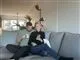Parret sidder i en sofa med en kop kaffe og kigger ned i en telefon.