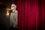 En mand bag et teatergardin
