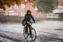 En mand kommer cyklende i regnvejr