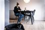 En kvinde sidder ved sit spisebord