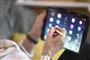 person sidder med tablet 