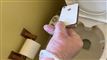 Mand holder iPhone over toiletkumme