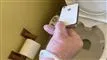 Mand holder iPhone over toiletkumme