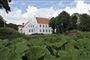 En stor hvid herregård med park foran