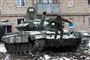 En russisk soldat hopper ned fra en tank.