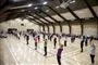 En sportshal hvor mange mennesker gør gymnastik