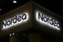 Nordeas logo lyser op i mørke på en bygning