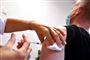 En mand får en vaccine i overarmen. 