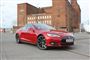 En tesla foran et kraftværk