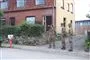 Tre hjemmeværnsfolk foran en udbrændt villa. 
