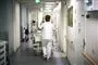En sygeplejerske går ned ad en hospitalsgang