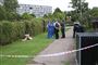 Politi og teknikere bag en afspærring i et boligområde. 