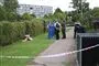 Politi og teknikere bag en afspærring i et boligområde. 