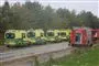 Mindst fire ambulancer og to brandbiler holder på ræd og række på en hovedvej.
