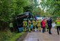 En bus holder halvt i grøften med mange redningsfolk omkring.