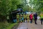 En bus holder halvt i grøften med mange redningsfolk omkring.