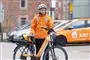person i orange tøj står ved elcykel 