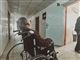 En person i en kørestol på en hospitalsgang med ryggen til