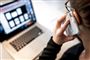 person taler i telefon ved computeren
