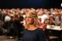 en blond dame ved en stor forsamling