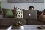 En mand med en Mac i en sofa