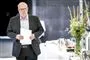 mand i jakkesæt står med papir