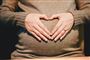 En gravid mave med hænder omkring formet som et hjerte