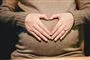 En gravid mave med hænder omkring formet som et hjerte