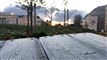frostklædte træplanker og huse i baggrunden