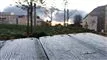 frostklædte træplanker og huse i baggrunden