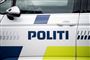 En politibil set fra siden. Den er hvid med blå skrift.