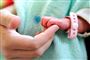 En baby holder i en voksens finger