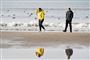 personer går ved strand